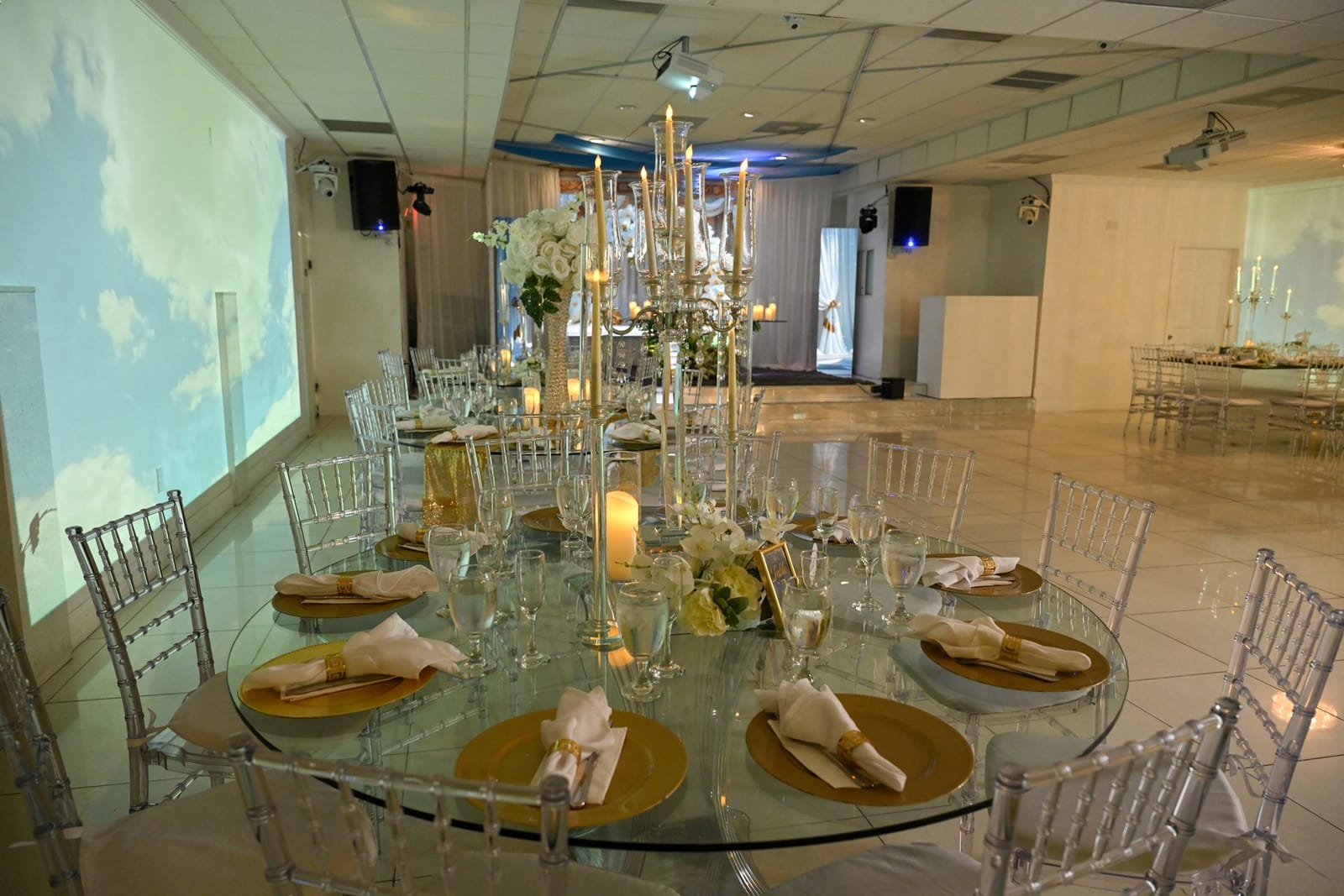 Mesa de boda con cielo de nubes proyectado en las paredes